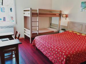 杜尔涅Logis Hotel Restaurant de la Montagne Noire的一间卧室配有一张床和一张双层床。