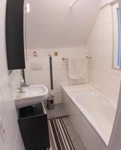 巴登-巴登Suite mit Blick auf die Lichtentaler Allee的白色的浴室设有浴缸和水槽。