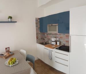 维罗纳Suite Home Sophie的厨房配有桌子和白色冰箱。