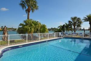 圣徒皮特海滩西风海滨度假酒店的一个带围栏和棕榈树的游泳池