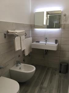 兰佩杜萨Le Anfore Hotel - Lampedusa的一间带水槽、卫生间和镜子的浴室