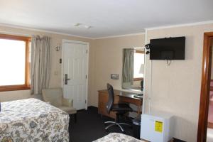 韦斯特菲尔德榆树汽车旅馆的酒店客房设有一间带书桌和床的卧室