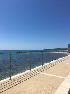 夏卡Appartamento Mare Blu的海边的步行道,带围栏
