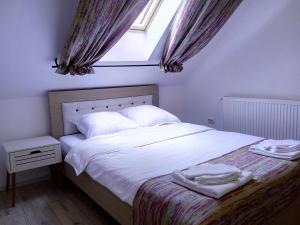 斯勒尼克Vila Slanic的一间卧室配有一张带白色床单的床和一扇窗户。