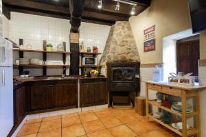 帕萨若Natural&Mente El Tomillar的厨房配有木制橱柜和大型石炉。