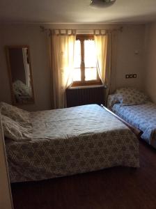 圣玛丽德康庞比利牛斯宾馆的一间卧室设有两张床和窗户。