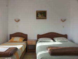 乌尔齐尼Guesthouse Domenik的两张睡床彼此相邻,位于一个房间里