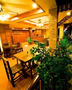 芭东海滩Baan Sudarat Hotel的用餐室配有桌椅和植物