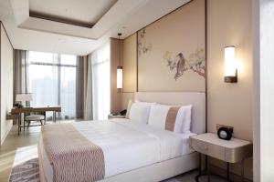 台北美福大饭店的卧室配有一张白色大床和一张书桌