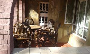 内罗毕Kepro Farm的桌子和椅子坐在大楼外