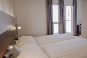林茨施瓦茨巴尔酒店的卧室内的白色床和窗户
