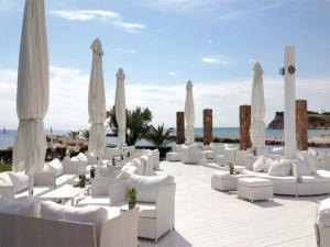撒尼海滩Mira Forest Residences的海滩上的一组白色椅子和遮阳伞