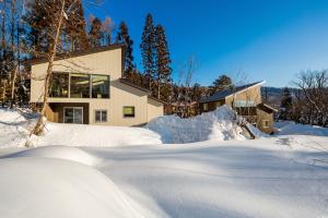 白马村Solar Chalets by Hakuba Hospitality Group的雪中的房子,积雪