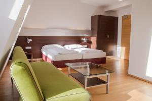 林茨施瓦茨巴尔酒店的一间卧室配有一张床、一张沙发和一张桌子