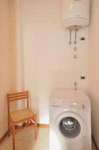 比比翁Residence Millennium的洗衣房配有洗衣机和椅子