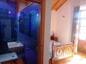 AngejaSolar do Alambique的浴室配有水槽和蓝色瓷砖墙。