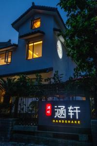 杭州涵轩优选民宿的蓝色的建筑,前面有标志