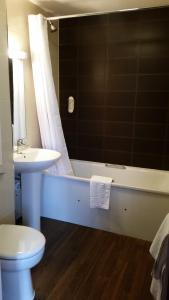 伯明翰威瑟斯本石南玫瑰酒店的浴室配有卫生间、浴缸和水槽。