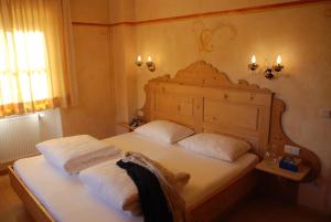 圣坎迪朵Piccolohotel Tempele Garni的一间卧室配有一张带两个白色枕头的床