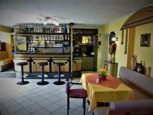 沃尔特湖畔韦尔登潘森费佛多否酒店的餐厅设有酒吧,配有桌椅
