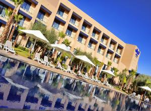 马拉喀什瓦佐酒店的一座配有椅子的酒店,酒店前方设有一个游泳池