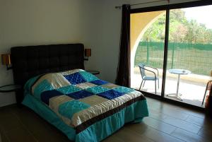 加莱里亚阿里弗酒店的一间卧室配有一张床、一张桌子和一个窗户。