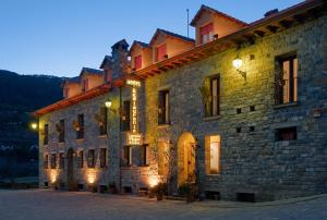 SiresaHotel Castillo d'Acher的一座带灯光的大型石头建筑