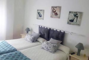 莱德斯马Las Cadenas的卧室配有两张床,墙上挂有两张照片
