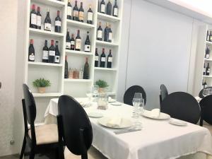 莱德斯马Las Cadenas的一张带黑色椅子的白色桌子和一瓶葡萄酒