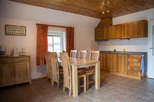 PelčiFox House的厨房配有木桌和椅子
