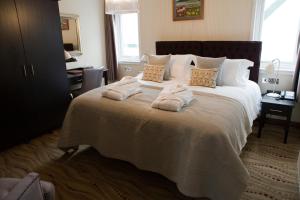 斯坦利海滨精品酒店的一间卧室配有一张大床和毛巾