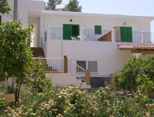 伊斯费古耶拉尔海滩拉斯特雷斯戈朗德里纳斯酒店的白色的房子,设有绿色的门和楼梯