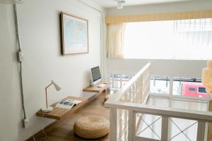 清迈帕克平旅舍的客房设有带书桌和电视的楼梯。