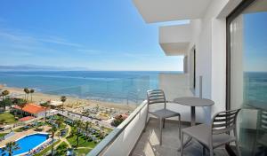 多列毛利诺斯Hotel Ocean House Costa del Sol, Affiliated by Meliá的阳台配有桌椅,享有海景。