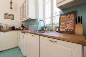 耶路撒冷塔比耶珍宝全新公寓的厨房配有白色橱柜和水槽