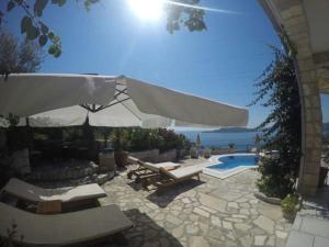 斯韦蒂·斯特凡Villa Royal Dream的一个带游泳池、遮阳伞和椅子的庭院