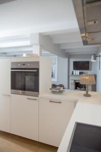 汉堡艾尔克塔格公寓的厨房配有白色橱柜和炉灶。