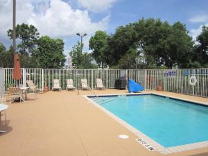劳德代尔堡美洲长住酒店 - 劳德代尔堡 - 柏溪 - 西北6号的一个带椅子和围栏的游泳池