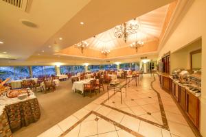 吉塞尼Lake Kivu Serena Hotel的一间在房间内配有桌椅的餐厅
