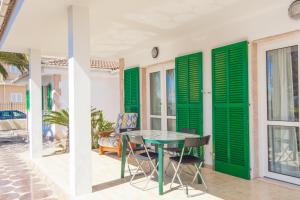 穆罗海滩Rodriguez De La Fuente 19 (Sin Nombre)的庭院设有绿色百叶窗和桌椅
