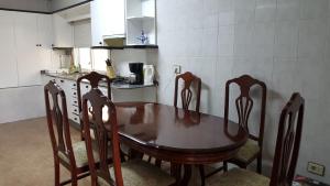 米尼奥Mino Apartamento的厨房里配有一张木桌和椅子