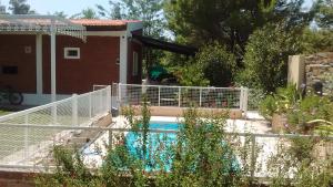 波特雷罗德洛斯弗内斯Cabañas Molinos de Vientos的一座房子旁的游泳池,设有白色的围栏