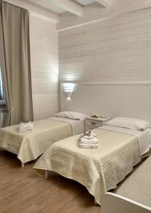 吉诺萨滨海Le Camelie的一间设有两张床铺和毛巾的房间