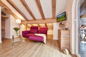 加尔米施-帕滕基兴Ferienwohnung Wittmann的客厅配有紫色沙发和电视