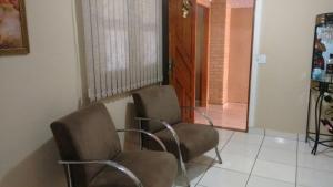 奥林匹亚Casa em Olimpia 2的一间房间,配有两把椅子和一扇门,通往一个房间