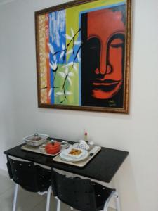 São JorgeShopping Motel Santa Maria do Pará的一张桌子,上面有盘子食物和墙上的画