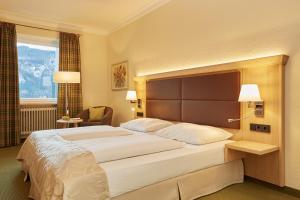 格赖瑙艾比塞酒店的一张大床,位于酒店带两盏灯的房间