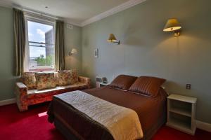 霍巴特阿斯特私人酒店的卧室配有床、椅子和窗户。