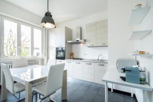 Villa Guardia卡萨福斯克罗公寓的厨房配有白色橱柜和桌椅