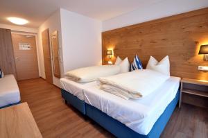 瓦尔滕霍芬Gästehaus zur Krone的酒店客房配有带白色床单和枕头的床。